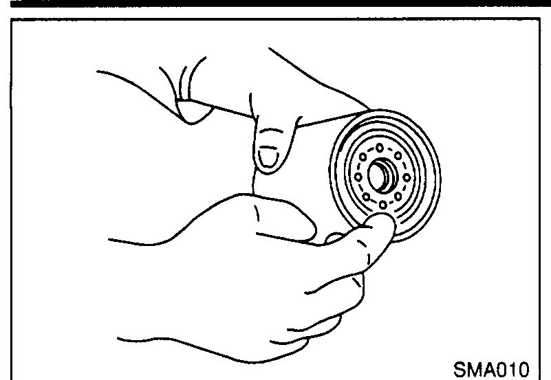 Hand applying CVT fluid to the rubber seal of the new oil filter cartridge.