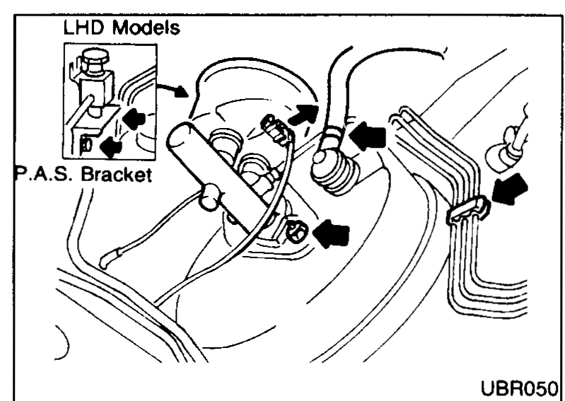 RHD models — booster removal access. Arrows indicate that brake pipes (from the master cylinder side) and the P.A.S. (power-assisted steering) bracket must be displaced for access to the booster mounting and clevis pin. View into the engine bay from above.