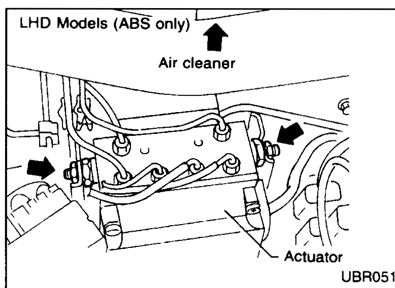 LHD models (ABS only) — booster removal access. Air cleaner must be removed, and care taken not to foul ABS actuator. Arrows point at the air cleaner above and at the ABS actuator on the inner fender.