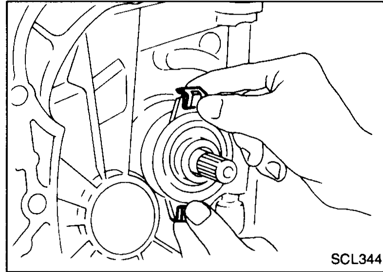 Mechanic's hand pulling a bearing retainer outward from the clutch housing to release the release bearing.