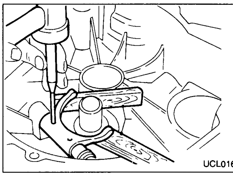 Punch and hammer being used to tap a retaining pin out through the cavity of the clutch housing.