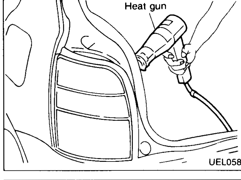 Heat-gun warming of rear-lamp mastic — applied from inside luggage area to soften butyl seal before pulling lens unit away.