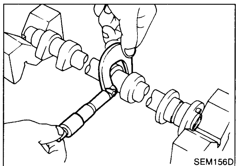 Camshaft held between V-blocks; a micrometer measures the outer diameter of a camshaft journal.