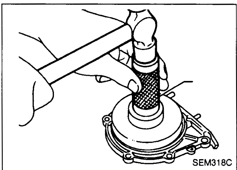 Hand using a hammer and a suitable drift / installer tool to drive a new oil seal into the rear oil seal retainer.