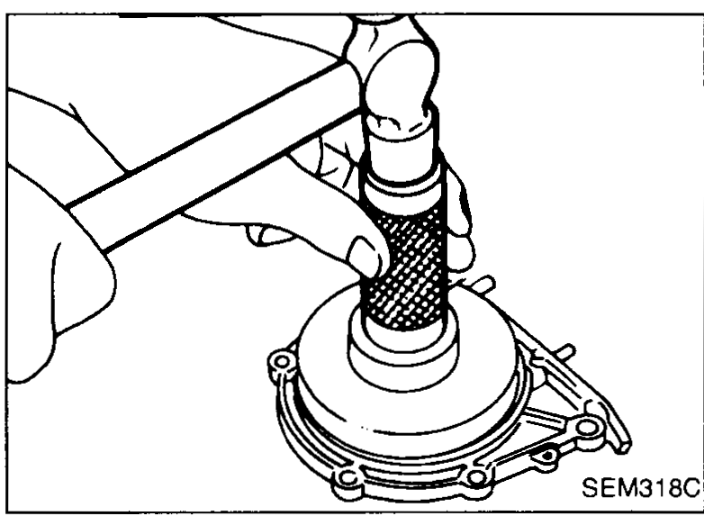 Pry tool removing the rear crankshaft oil seal from the rear oil seal retainer.