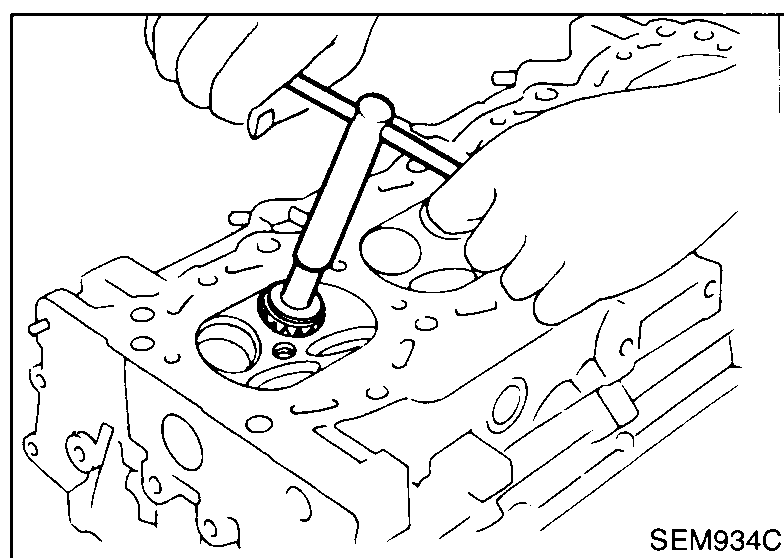 Hand-reamer reaming a freshly-pressed service valve guide in the cylinder head from above to bring inner diameter to finished size.