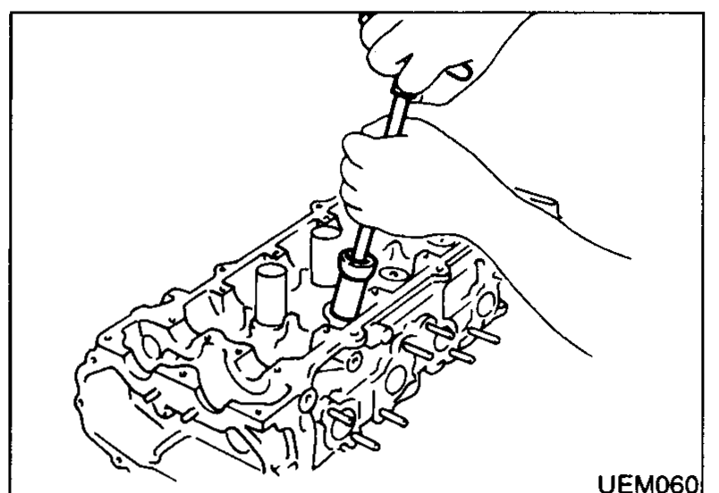 Hand using a tool to extract the valve oil seal from a valve guide on the cylinder head.