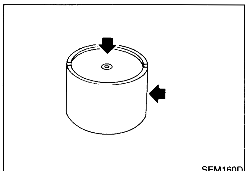 Valve lifter (bucket / shim-on-top tappet) viewed in elevation with arrows indicating the contact surfaces to inspect: the top face (cam contact) and the side (bore sliding face).