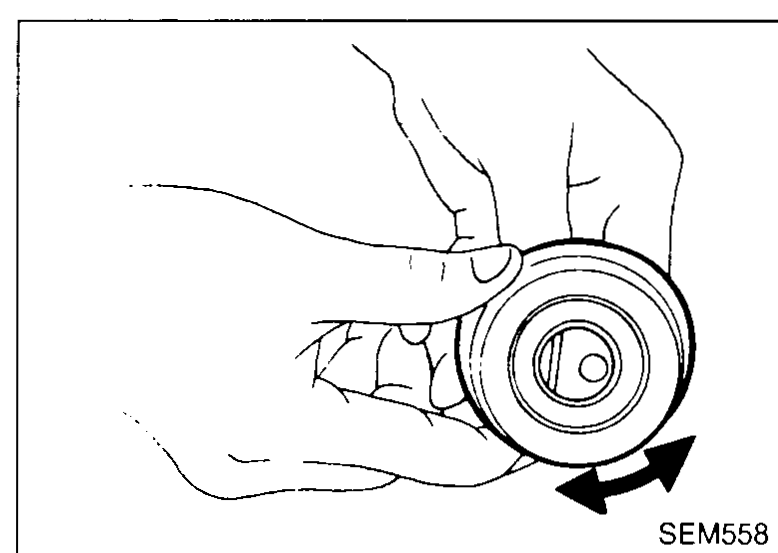 Hand spinning a tensioner/idler pulley by hand to check for smooth rotation — illustrates 'Check belt tensioner and idler for smooth turning'.