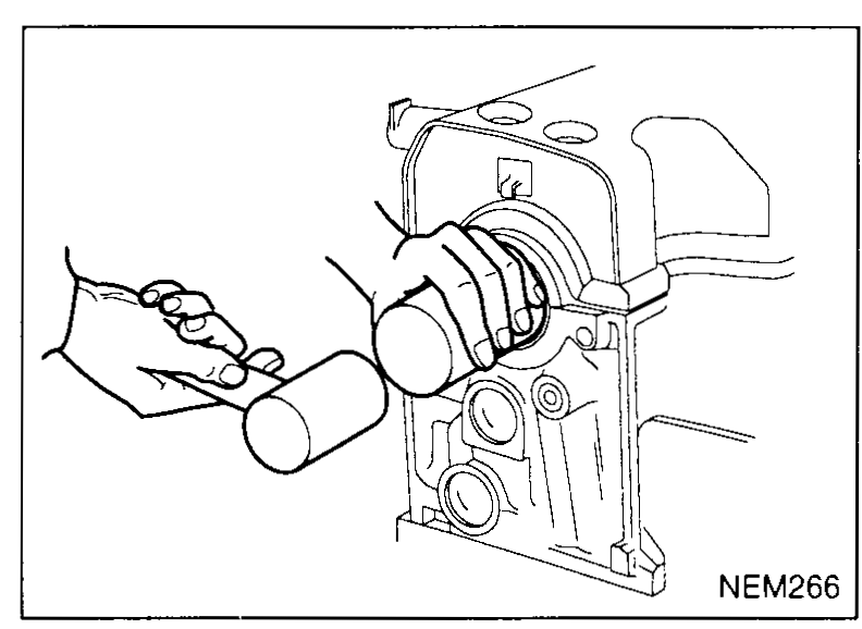 Hand using a tubular driver to seat a new camshaft oil seal onto the front of the cylinder head — illustrates camshaft-oil-seal step 3.