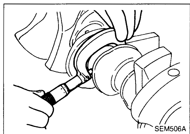 Hand using a micrometer to measure the outer diameter of a crankshaft pin journal — illustrates Inspection step 4 (measure conrod-pin journal OD).