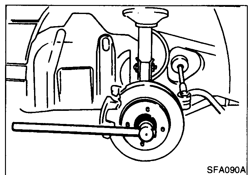 Photo of the front wheel-bearing lock nut being removed with a long breaker bar/socket while the brake disc is held with the brake pedal depressed.