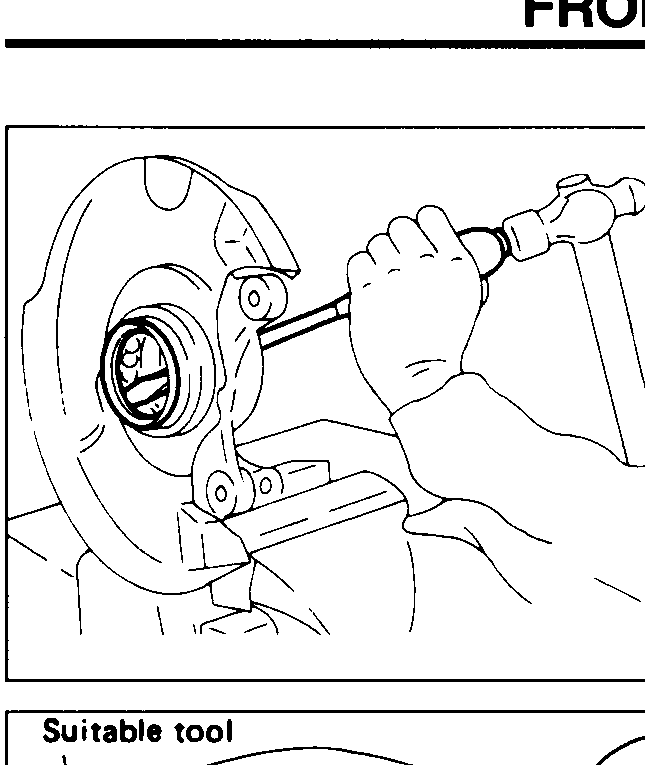 Mechanic using a flat-tip pick / screwdriver to pry the inner and outer grease seals out of the knuckle bore.