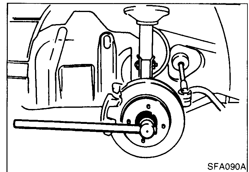 Photo of the front wheel-bearing lock nut being removed with a long breaker bar/socket while the brake disc is held with the brake pedal depressed.