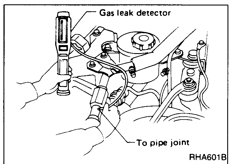 Gas leak detector wand probed at a refrigerant pipe joint in the engine bay during the preliminary leak check.