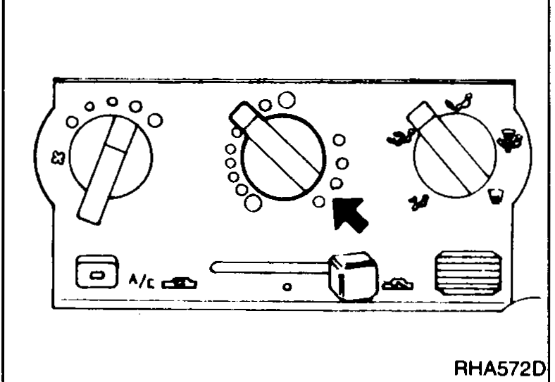 A/C control panel close-up with an arrow pointing up at the temperature-control dial being rotated to the full-hot (red) end.