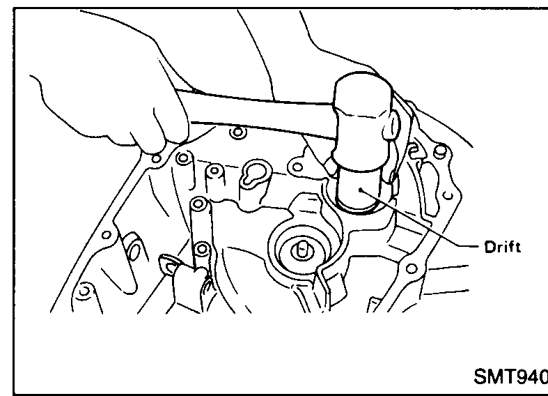 Installing a new input shaft oil seal into the clutch housing using a drift and hammer.