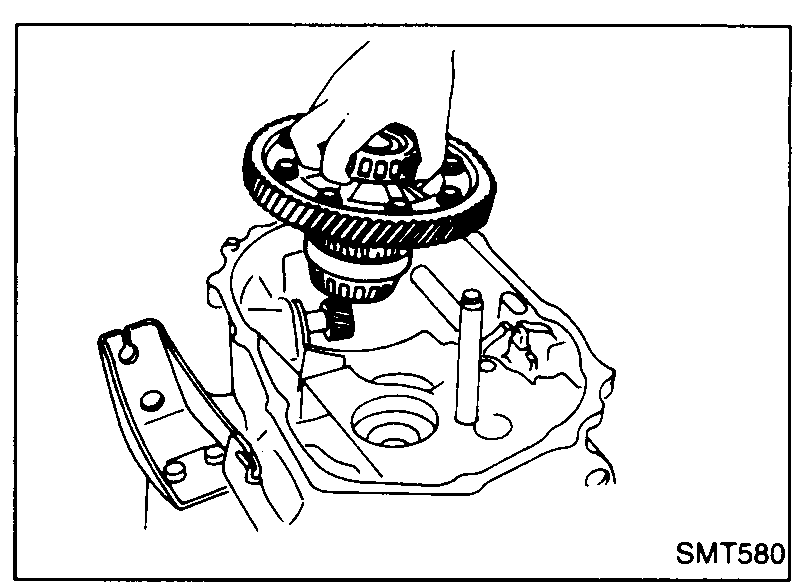Top view of clutch housing with the reverse idler gear and final drive assembly being lifted out by hand.