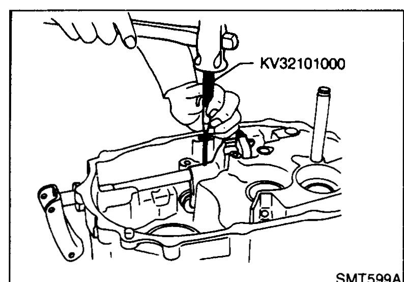 Special tool KV32101000 (pin punch) being used to drive the retaining pin out of the striking lever.