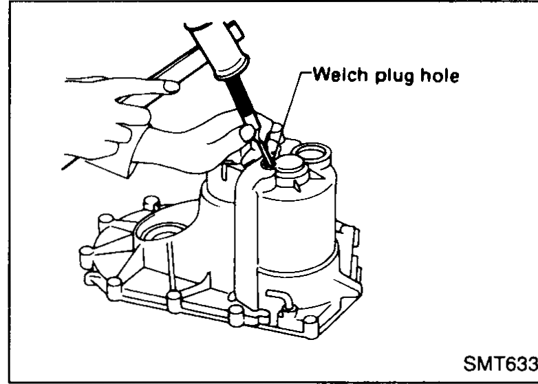 Inside view of transmission case showing the welch plug to remove and the input shaft rear bearing bore beyond it.