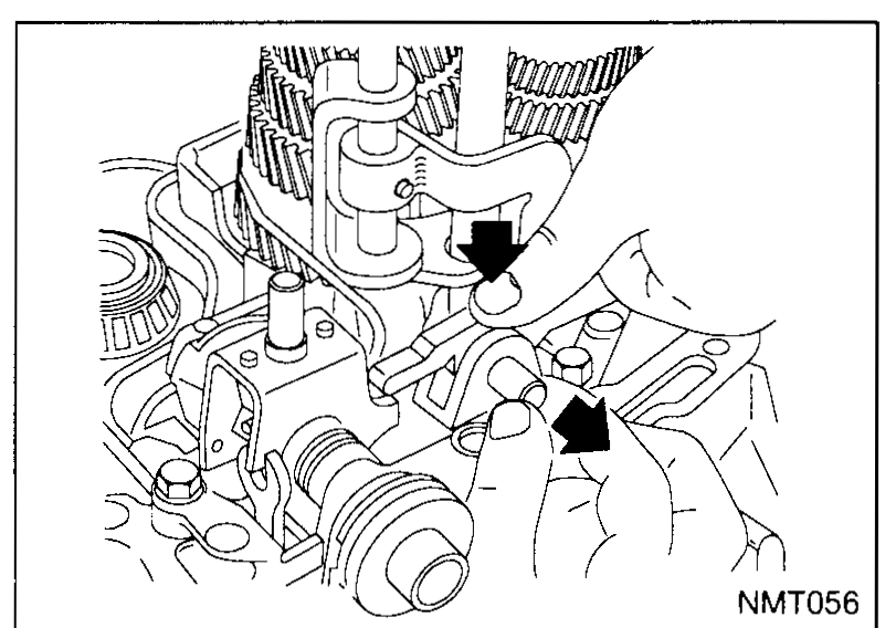 Close-up of the transaxle internals showing the reverse fork shaft and reverse fork. Two arrows point to the fork shaft and fork retainer locations being removed.