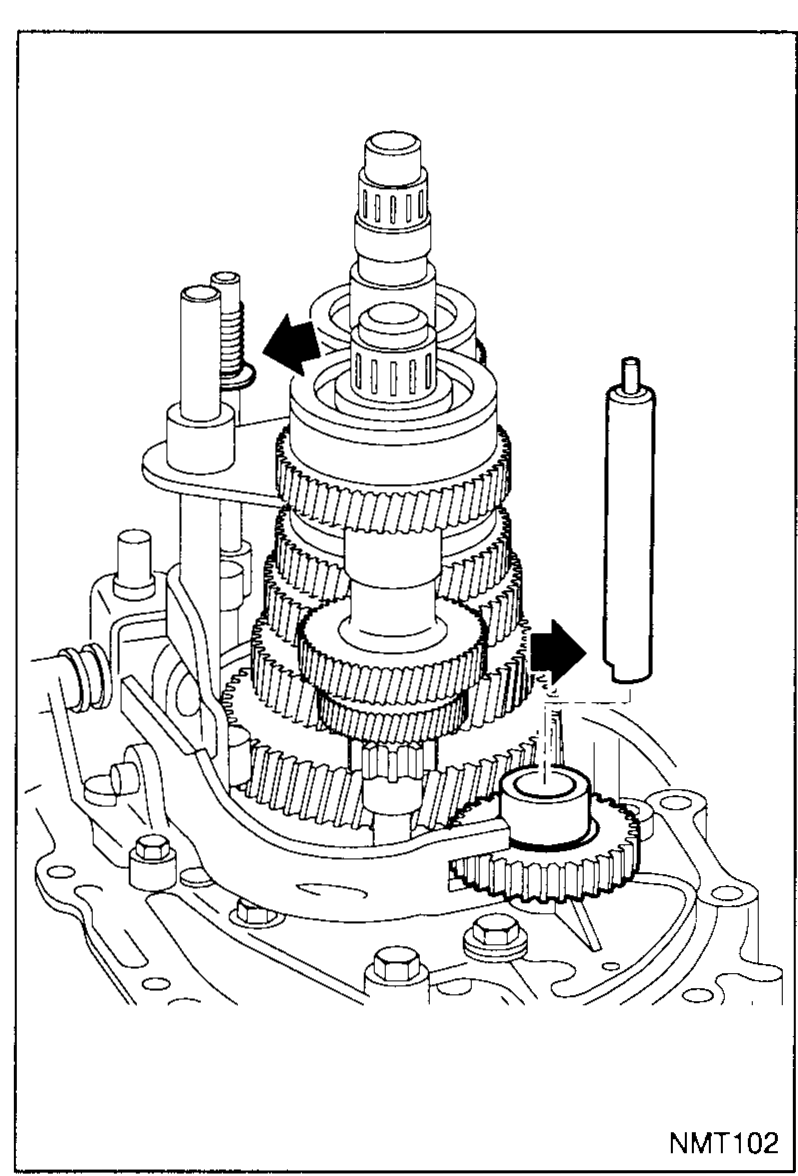 Transaxle gear-train installed in the casing viewed from above with the reverse idler gear and idler shaft visible to the left of the main gear stack. A black arrow points to the step on the idler shaft that must seat in its housing.