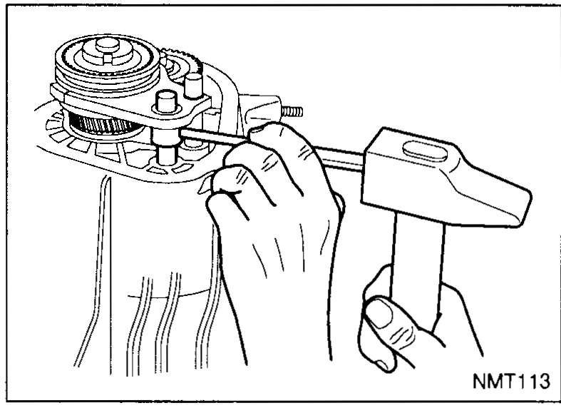 Torque wrench engaged on the mainshaft notched nut via socket / special tool KV32910060. The case is visible below. The tool label is called out by an arrow.